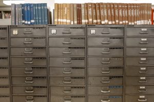 Grey steel filing cabinets with books on top