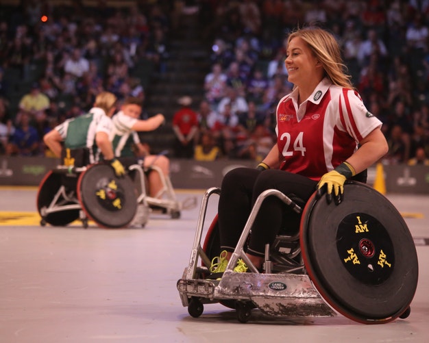 Woman in a wheelchair, wearing a sports shirt