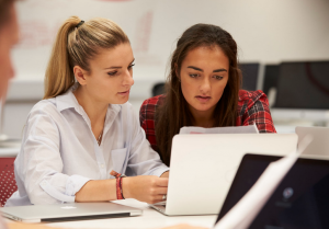 Two woman looking at laptop