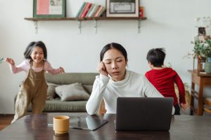 Moterh trying to study with kids running around her