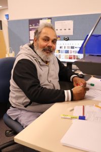 Middle aged aboriginal man sitting at desk