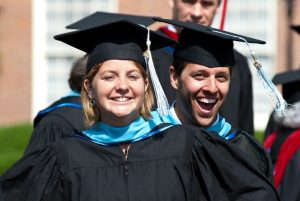 Stdents wearing graduation gowns and mrtatboards