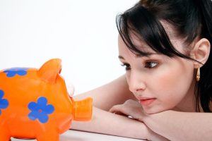 Woman looking at a piggy bank