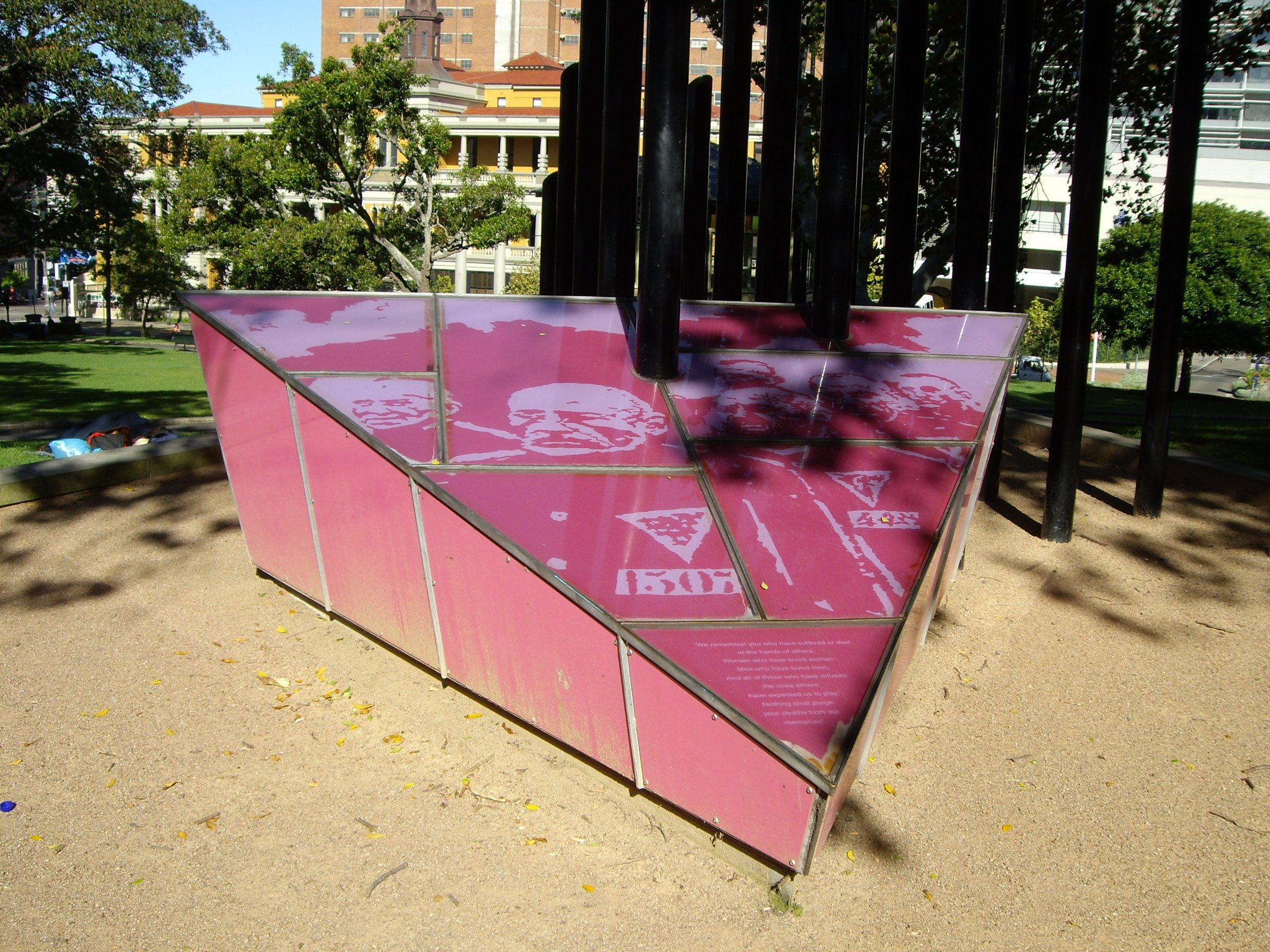 Photo of a monument designed as a large pink triangle with images of people's faces