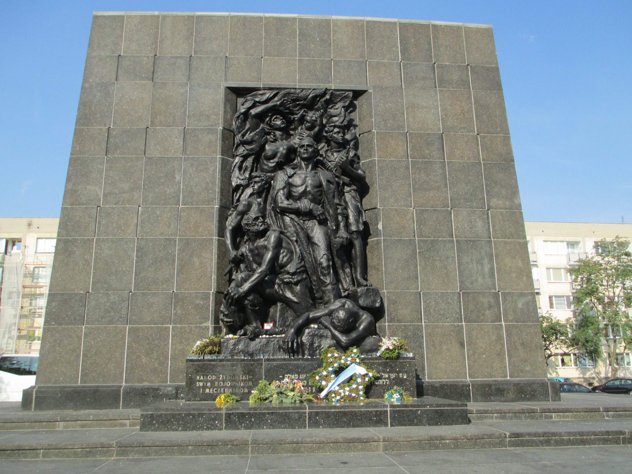 Dark sculpture of people embedded in a wall