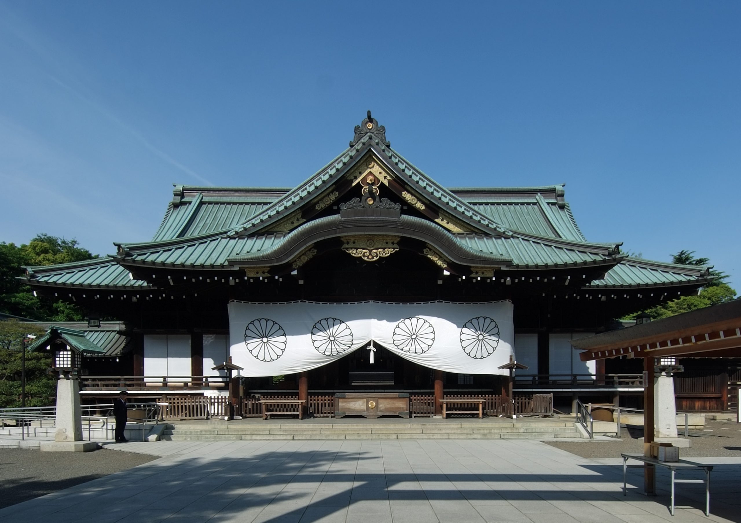 Photo of Yasukuni Shrine in Tokyo. It is a traditional looking Japanese shrine with a green roof