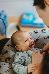 photo of a young infant looking at a caregiver’s face