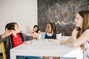 four children in a room with one child excluded