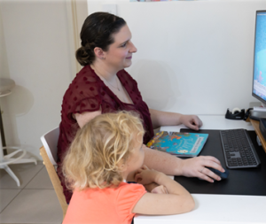 child and woman watching a computer screen