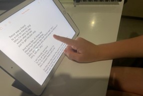 hand pointing on table screen at typed text