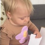 Toddler holding picture book and lifting flap