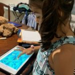 child pushing screen on iPad