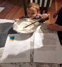 Toddler holding spoon in a mixing bowl