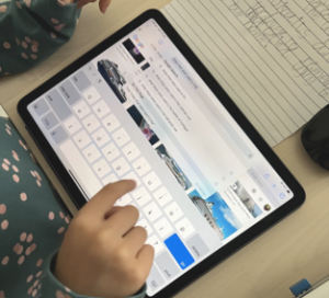 Child's fingers pushing keys on an iPad