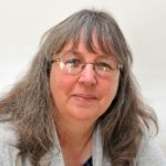 Kim Golding - a middle aged woman with long grey hair and glasses