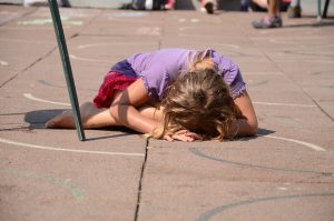 Child laying and crying on ground