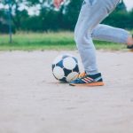 Legs surrounding a soccer ball