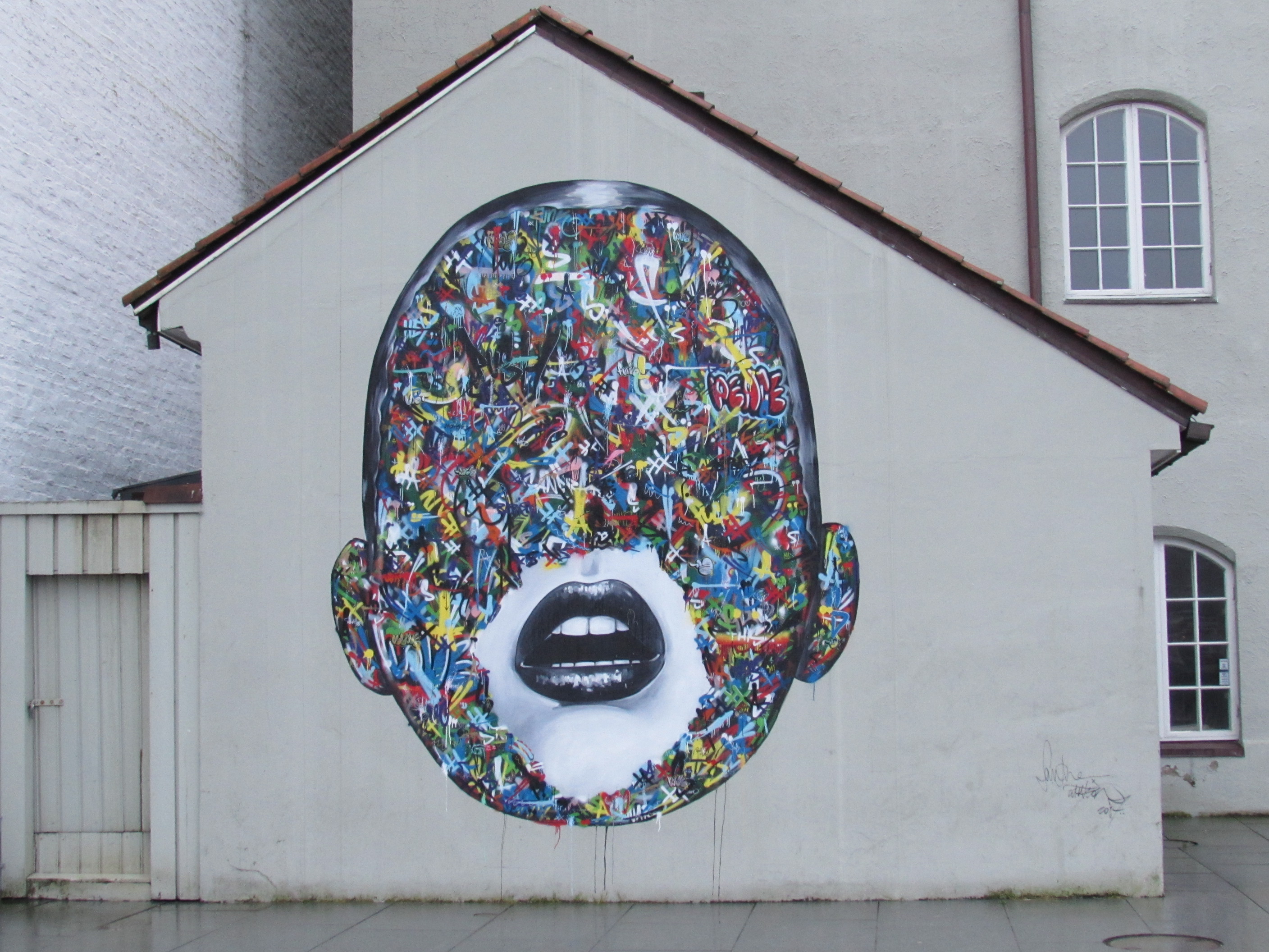 Street art of coloured fcae with black lips