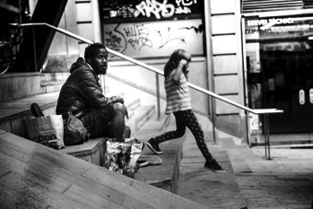 Black and white photo of black man sitting on steps