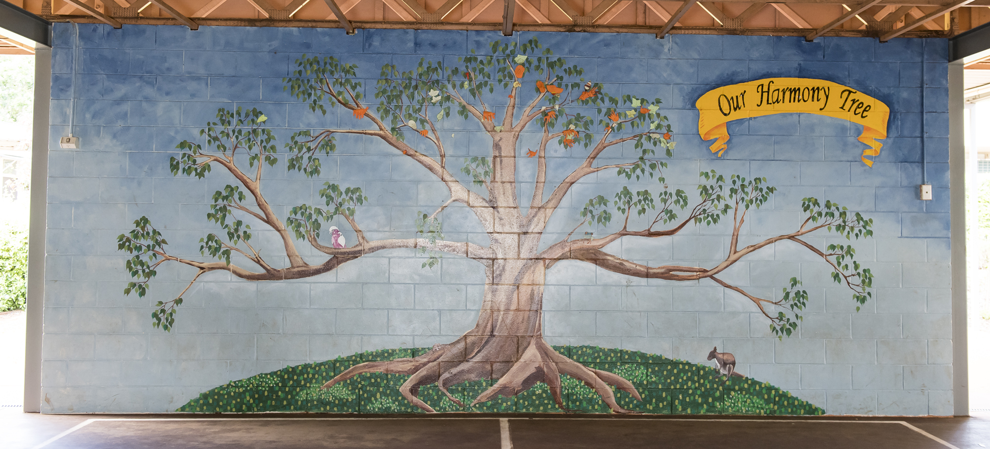 A mural of a tree titled the harmony tree, respresenting school values