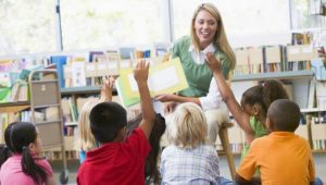 Teacher reading picture book to children