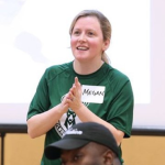 Meggan - a white woman with mousy brown hair dressed in sporty green shirt.
