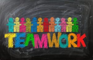 A decorative image showing a blackboard with the word 'teamwork' and interlocking stylised human figures.